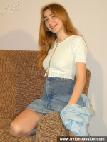 Girl in stockings undressing and posing on a couch