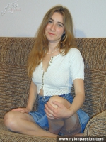 Girl in stockings undressing and posing on a couch