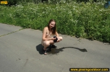 Teen girl pissing on asphalt outdoor