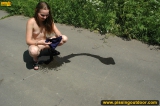 Teen girl pissing on asphalt outdoor