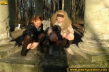Two girls outdoor pissing on stone columns